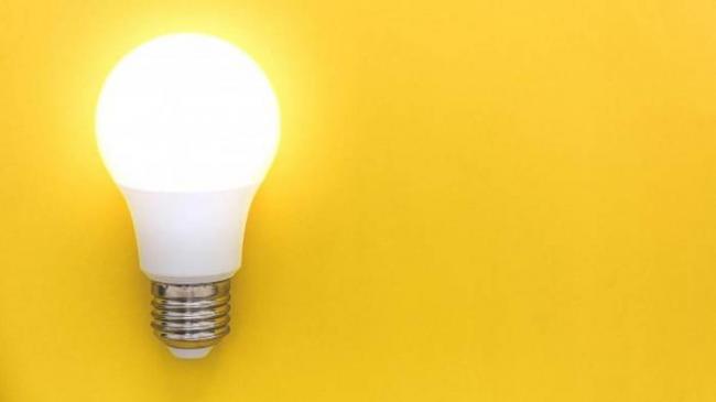 Лампочка светится на желтом фоне