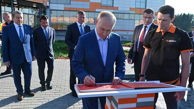 Владимир Путин подписывает фотоальбом об этапах строительства Центральной кольцевой автомобильной дороги