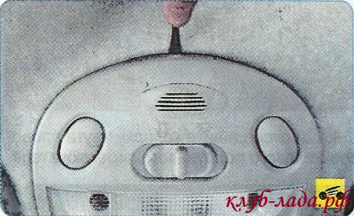 Нажать на пластиковый фиксатор крышки блока освещения салона.